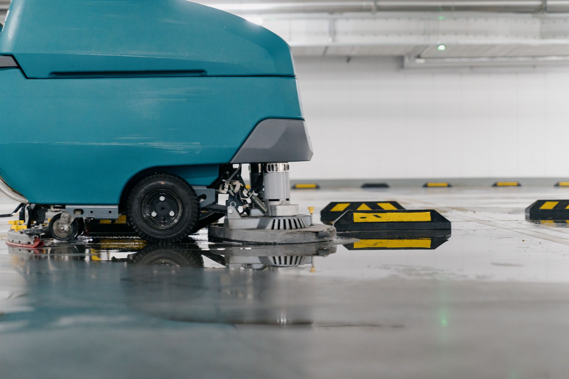 Cleaners are cleaning the parking lot with a machine